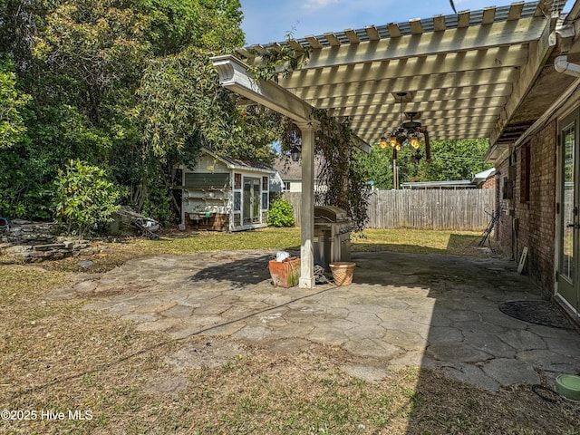 fenced backyard with a pergola, an outdoor structure, a patio area, and a storage unit
