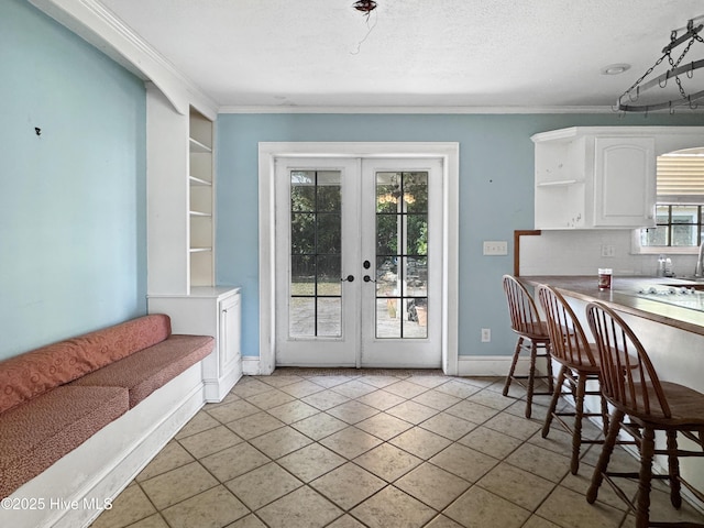 dining area featuring french doors, ornamental molding, baseboards, light tile patterned floors, and a textured ceiling