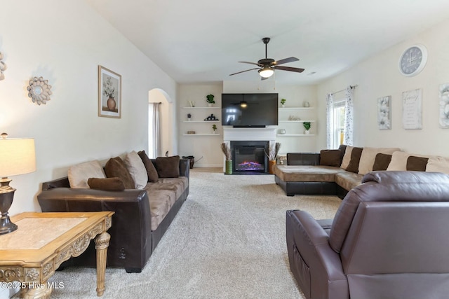 603 Coral Reef Ct, Sneads Ferry, NC 28460 - living room featuring light carpet, a ceiling fan, a glass covered fireplace, and arched walkways