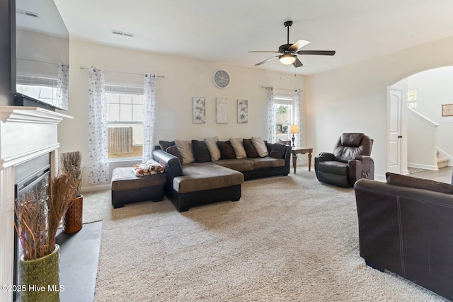 603 Coral Reef Ct, Sneads Ferry, NC 28460 - living area featuring arched walkways, visible vents, carpet, a ceiling fan, and stairs