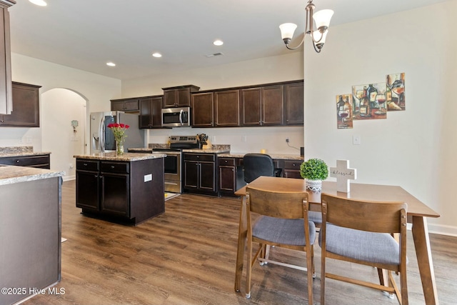 603 Coral Reef Ct, Sneads Ferry, NC 28460 - kitchen with arched walkways, a center island, dark brown cabinetry, appliances with stainless steel finishes, and dark wood-style flooring
