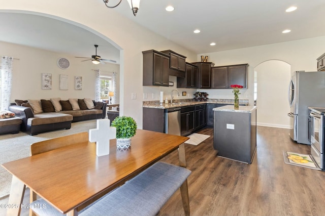 603 Coral Reef Ct, Sneads Ferry, NC 28460 - kitchen featuring arched walkways, dark brown cabinets, ceiling fan, and stainless steel appliances