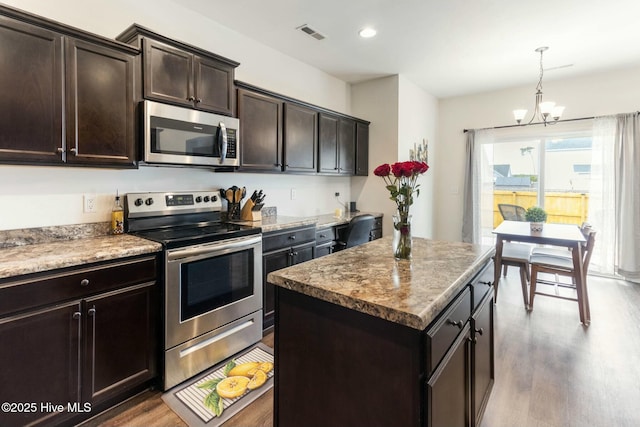 603 Coral Reef Ct, Sneads Ferry, NC 28460 - kitchen with a center island, visible vents, a chandelier, wood finished floors, and appliances with stainless steel finishes