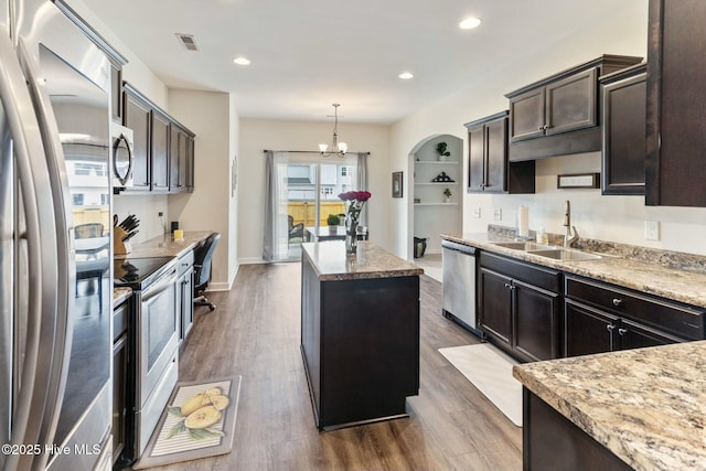 603 Coral Reef Ct, Sneads Ferry, NC 28460 - kitchen with dark wood finished floors, a sink, a kitchen island, a chandelier, and appliances with stainless steel finishes