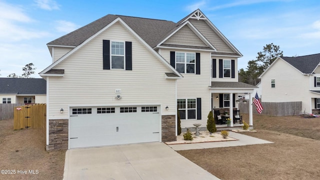 603 Coral Reef Ct, Sneads Ferry, NC 28460 - craftsman-style home with stone siding, concrete driveway, fence, and a garage