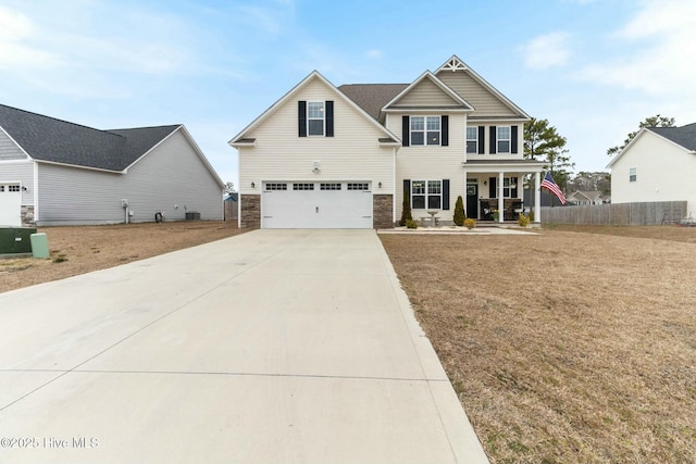603 Coral Reef Ct, Sneads Ferry, NC 28460 - view of front of property featuring concrete driveway, stone siding, covered porch, fence, and a garage
