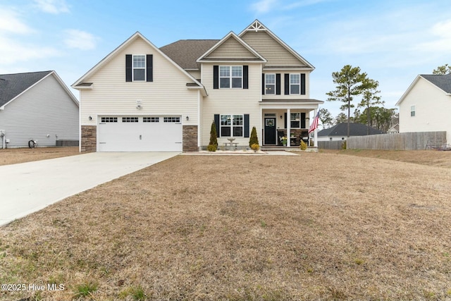 603 Coral Reef Ct, Sneads Ferry, NC 28460 - craftsman house featuring fence, concrete driveway, an attached garage, a porch, and stone siding