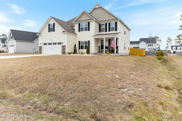 603 Coral Reef Ct, Sneads Ferry, NC 28460 - view of front of property featuring fence, concrete driveway, an attached garage, covered porch, and stone siding