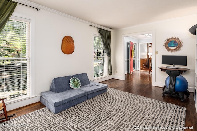 living area featuring ornamental molding and wood finished floors