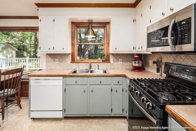 kitchen with stainless steel microwave, a sink, crown molding, gas stove, and dishwasher