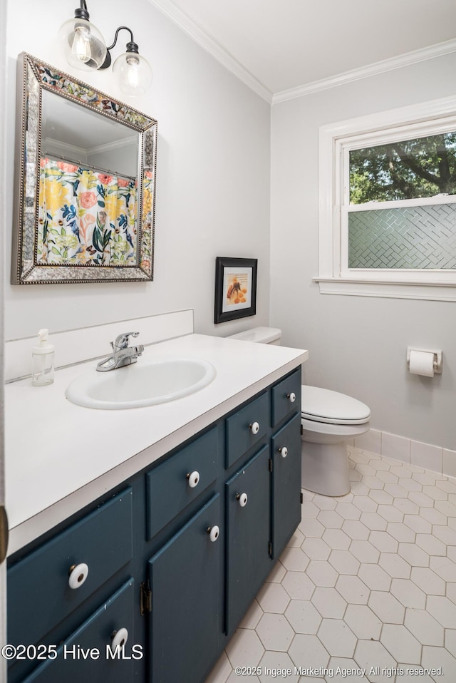 bathroom with crown molding, baseboards, toilet, tile patterned floors, and vanity