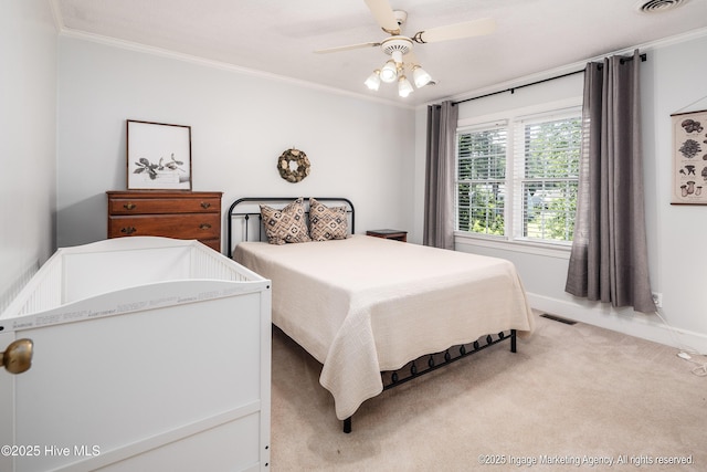 bedroom with ornamental molding, light carpet, and baseboards