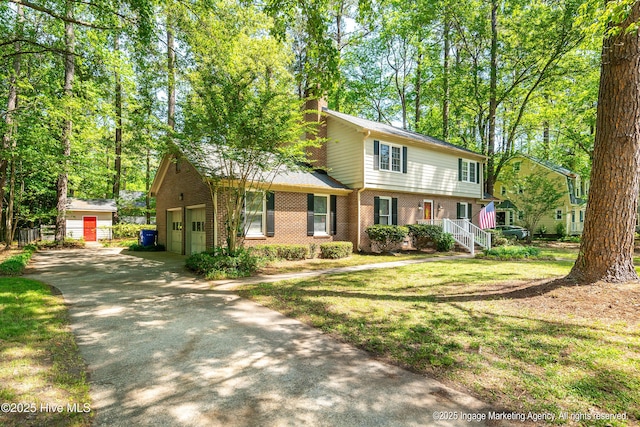 view of front of house featuring driveway, a chimney, and brick siding