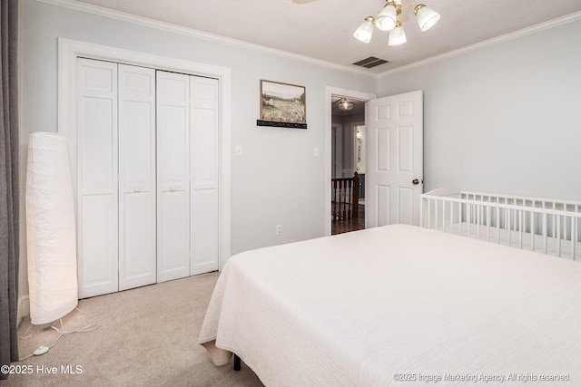 carpeted bedroom with visible vents, ceiling fan, ornamental molding, and a closet