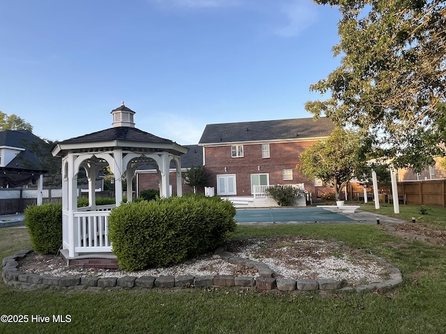 view of community featuring a gazebo, fence, a yard, and a pool