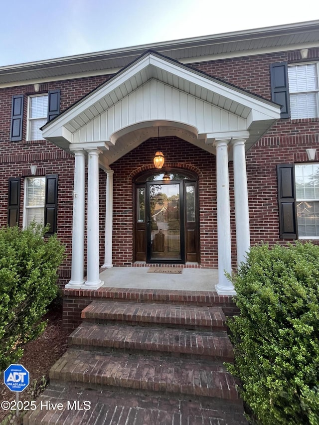 doorway to property with brick siding