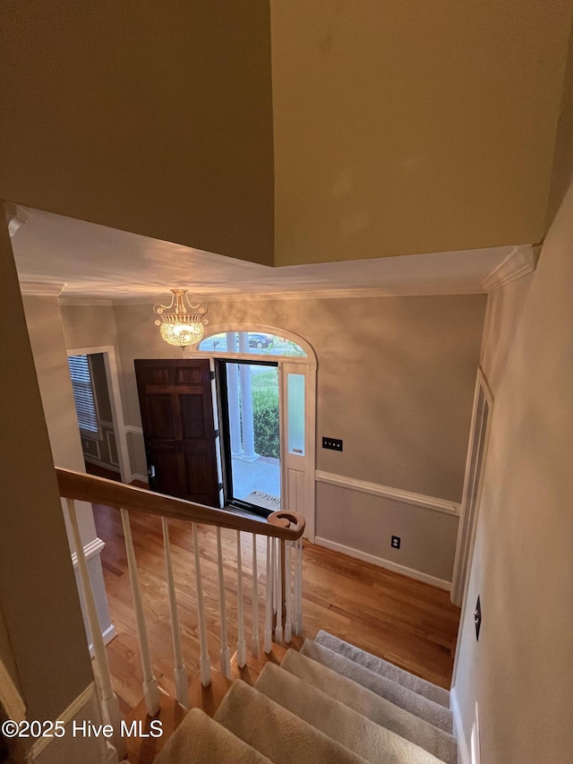foyer featuring baseboards, wood finished floors, stairway, and an inviting chandelier