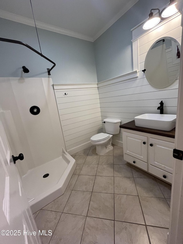 bathroom featuring crown molding, vanity, toilet, tile patterned floors, and a stall shower