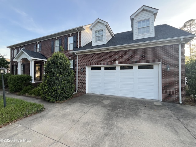 view of front of home with concrete driveway, brick siding, and roof with shingles
