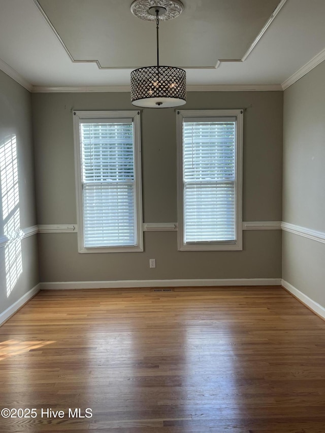 unfurnished room with crown molding, baseboards, and wood finished floors