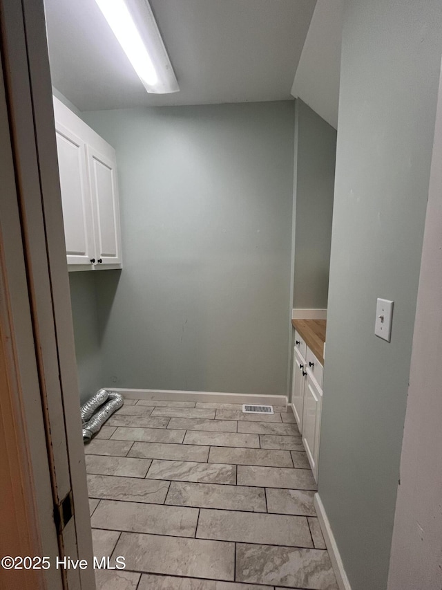laundry area with baseboards and visible vents
