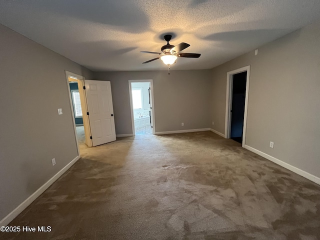 carpeted empty room featuring baseboards, ceiling fan, and a textured ceiling
