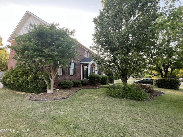 obstructed view of property with a front yard and brick siding