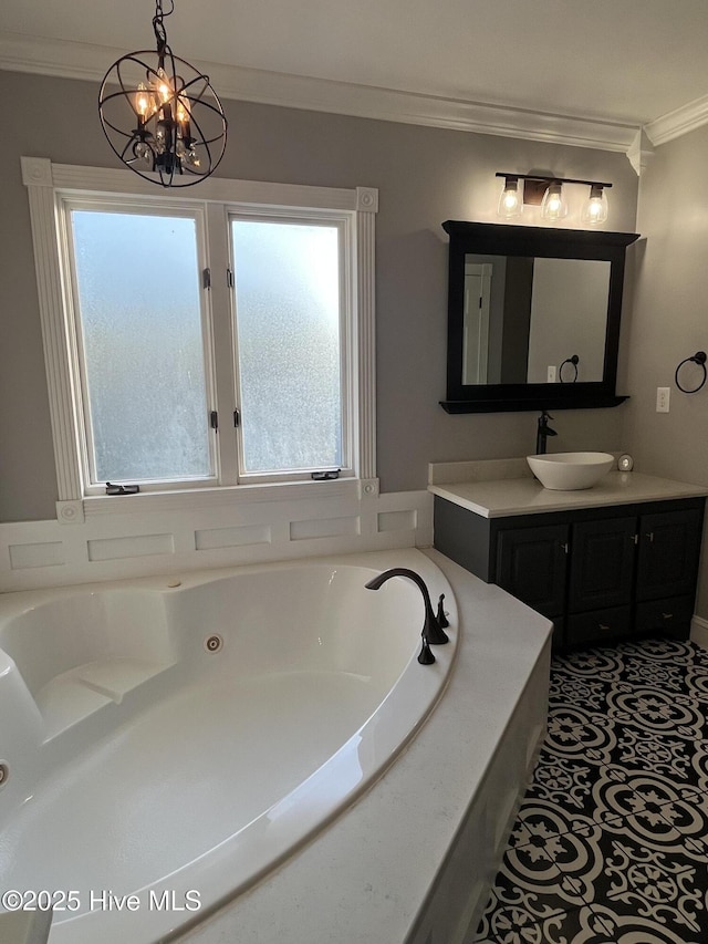 bathroom featuring a tub with jets, ornamental molding, a notable chandelier, and vanity