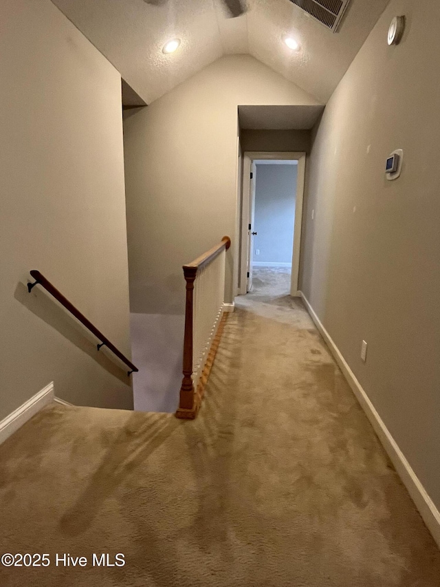 corridor with visible vents, carpet, baseboards, and an upstairs landing