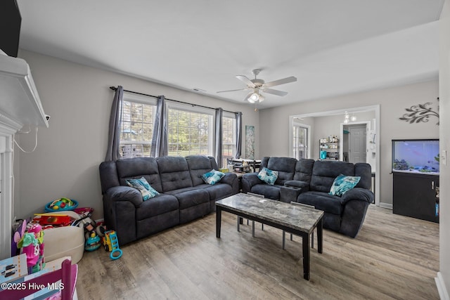 living room with ceiling fan and wood finished floors