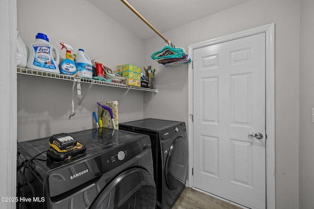 washroom featuring laundry area, wood finished floors, and washer and clothes dryer