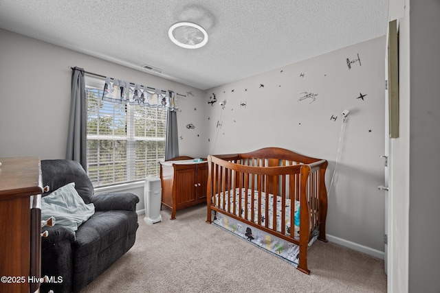 bedroom featuring light colored carpet, a textured ceiling, baseboards, and visible vents