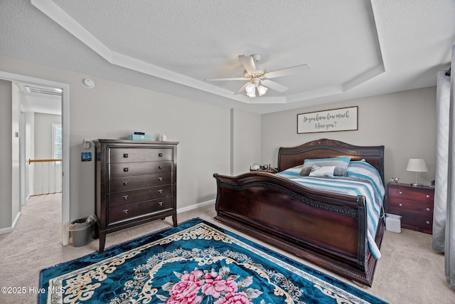 carpeted bedroom with baseboards, a textured ceiling, a raised ceiling, and ceiling fan
