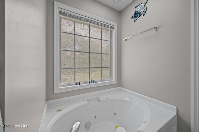 bathroom with a tub with jets and a wealth of natural light