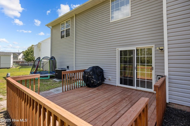 wooden terrace featuring fence, central AC unit, a lawn, and a grill
