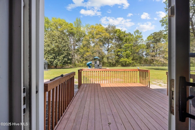 wooden deck featuring a yard and a playground
