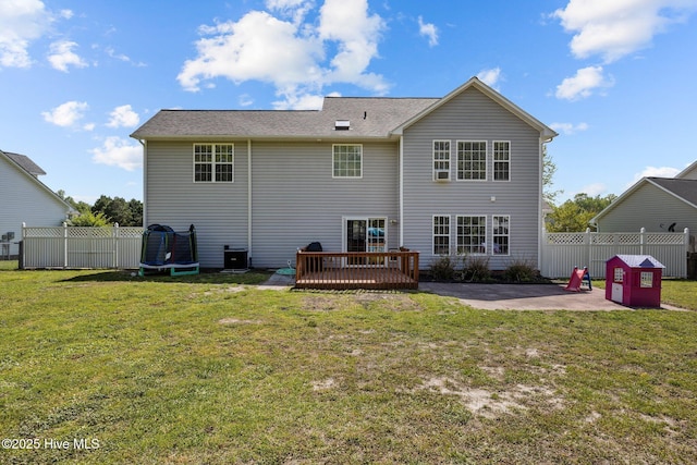rear view of property featuring fence, a patio, a yard, and a deck