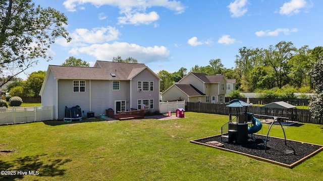 back of property with a playground, central air condition unit, a yard, and a fenced backyard
