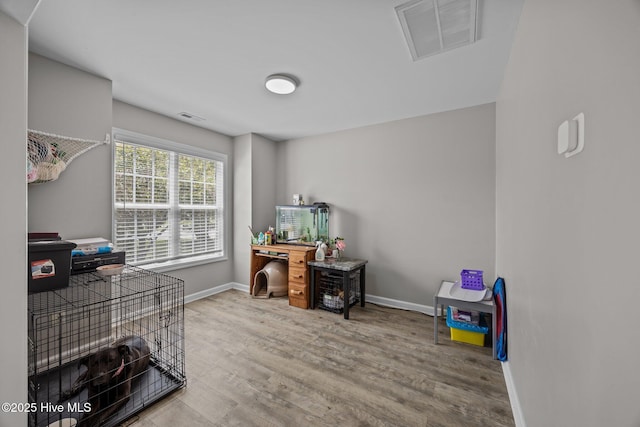 home office with baseboards, wood finished floors, and visible vents