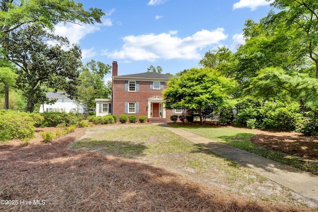 2405 Oleander Dr, Wilmington, NC 28403 - colonial-style house with brick siding, a front yard, and a chimney