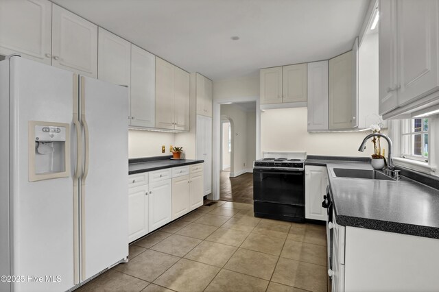2405 Oleander Dr, Wilmington, NC 28403 - kitchen featuring gas range oven, a sink, white fridge with ice dispenser, and dark countertops