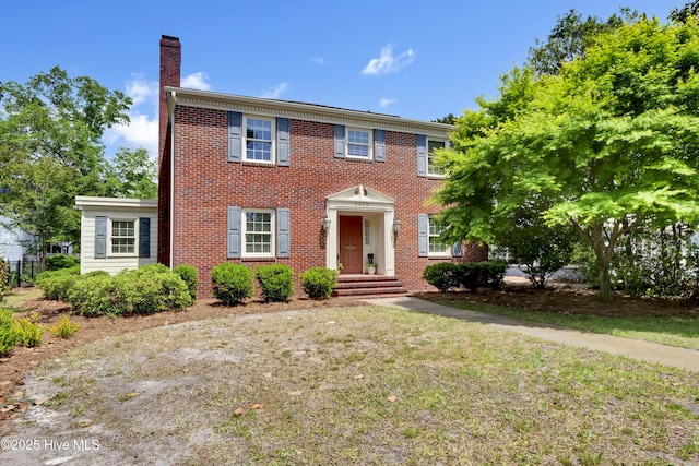 2405 Oleander Dr, Wilmington, NC 28403 - colonial-style house featuring a chimney, brick siding, and a front yard