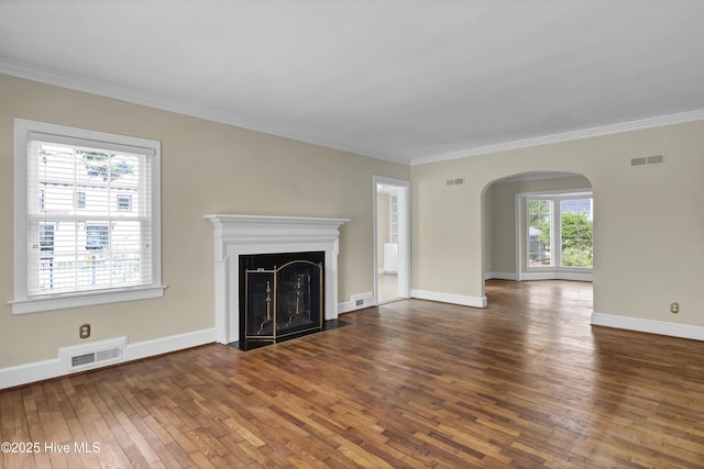 2405 Oleander Dr, Wilmington, NC 28403 - unfurnished living room featuring hardwood / wood-style flooring, arched walkways, ornamental molding, and visible vents