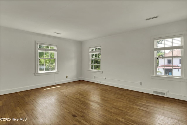2405 Oleander Dr, Wilmington, NC 28403 - empty room featuring wood-type flooring, visible vents, and a healthy amount of sunlight