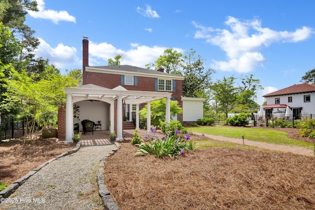 2405 Oleander Dr, Wilmington, NC 28403 - view of front facade featuring brick siding, a patio, a chimney, and fence