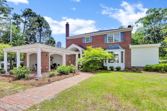 2405 Oleander Dr, Wilmington, NC 28403 - view of front of home featuring brick siding, a chimney, and a front lawn
