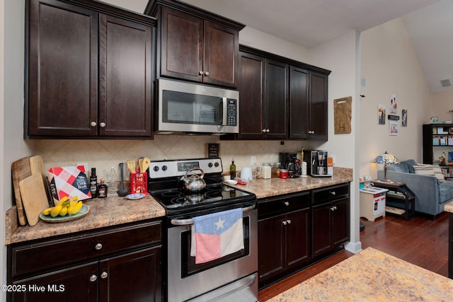 kitchen featuring tasteful backsplash, stainless steel appliances, vaulted ceiling, open floor plan, and dark wood-type flooring