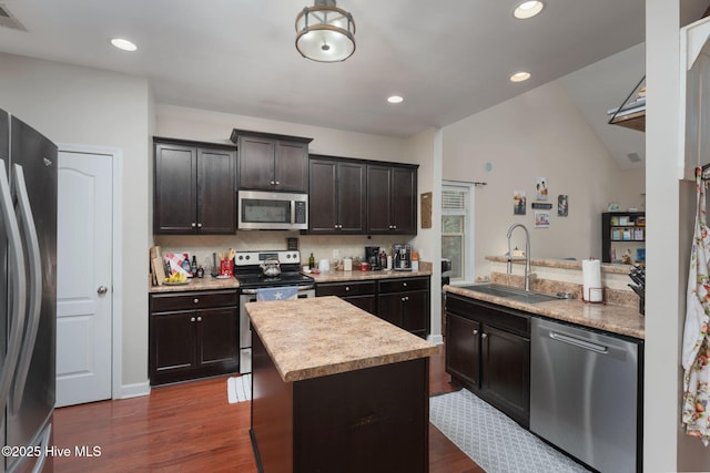 kitchen with dark wood-style floors, a sink, backsplash, light countertops, and appliances with stainless steel finishes