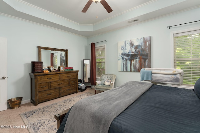 bedroom with carpet flooring, a raised ceiling, a ceiling fan, visible vents, and ornamental molding