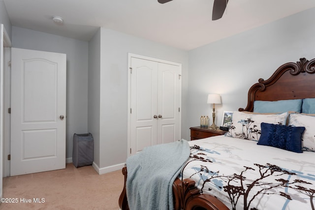 bedroom featuring a closet, baseboards, a ceiling fan, and light carpet